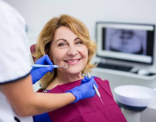Smiling woman receiving dental examination