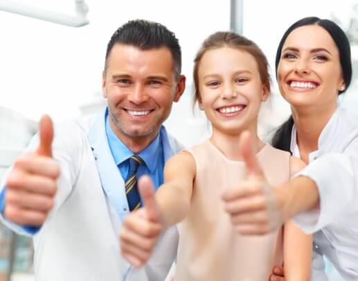 Dentist team member and young dental patient smiling together