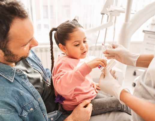 Child and parent talking to dentist about tooth colored fillings