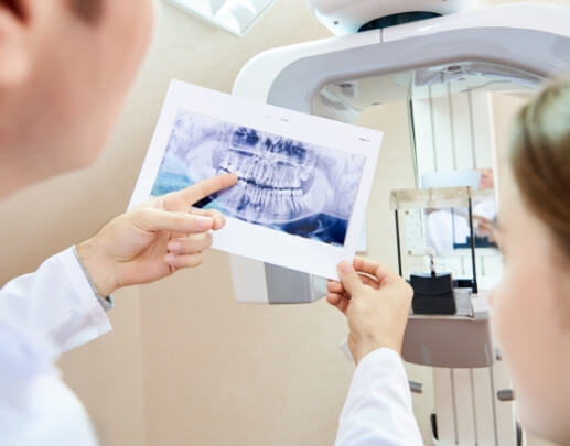 Dentist and dental patient looking at digital imaging photos