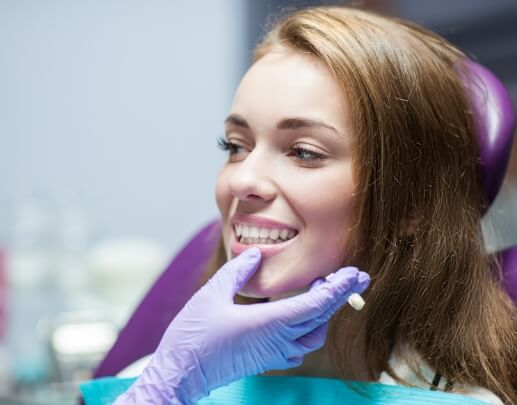 Dentist examining patient's smile after dental crown restoration