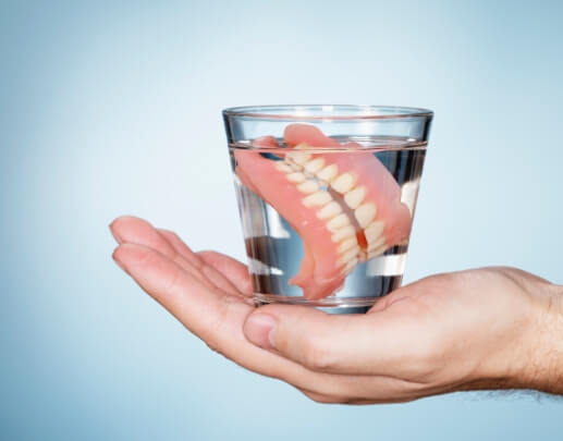 Set of dentures stored overnight in a glass of water