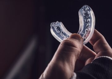 Hand holding a custom clear mouthguard