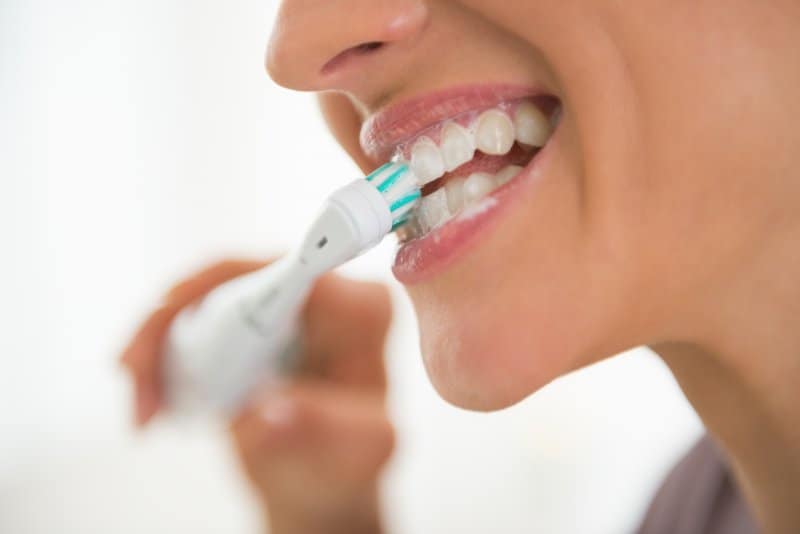 closeup of woman brushing teeth
